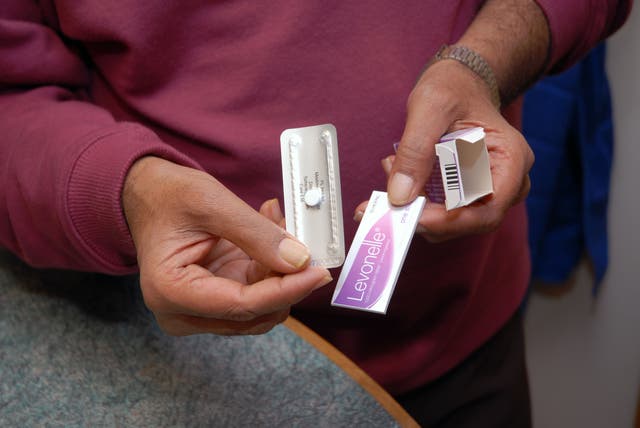 <p>A pharmacist holding the morning after pill</p>