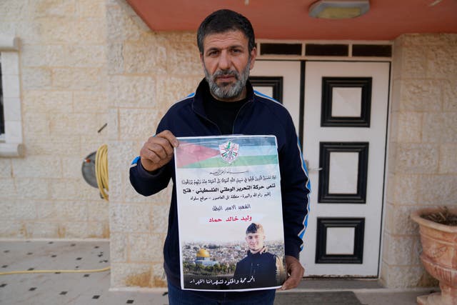 <p>Khalid Ahmad holds a poster of Waleed, 17 who died in an Israeli prison</p>