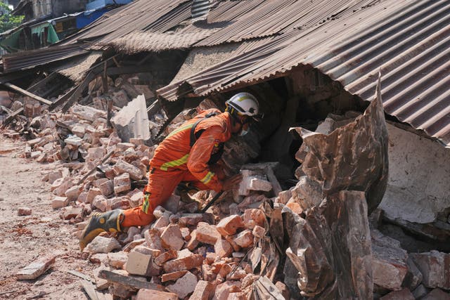 <p>File image of rescuer working through rubble of a collapsed building following the earthquake in Myanmar</p>