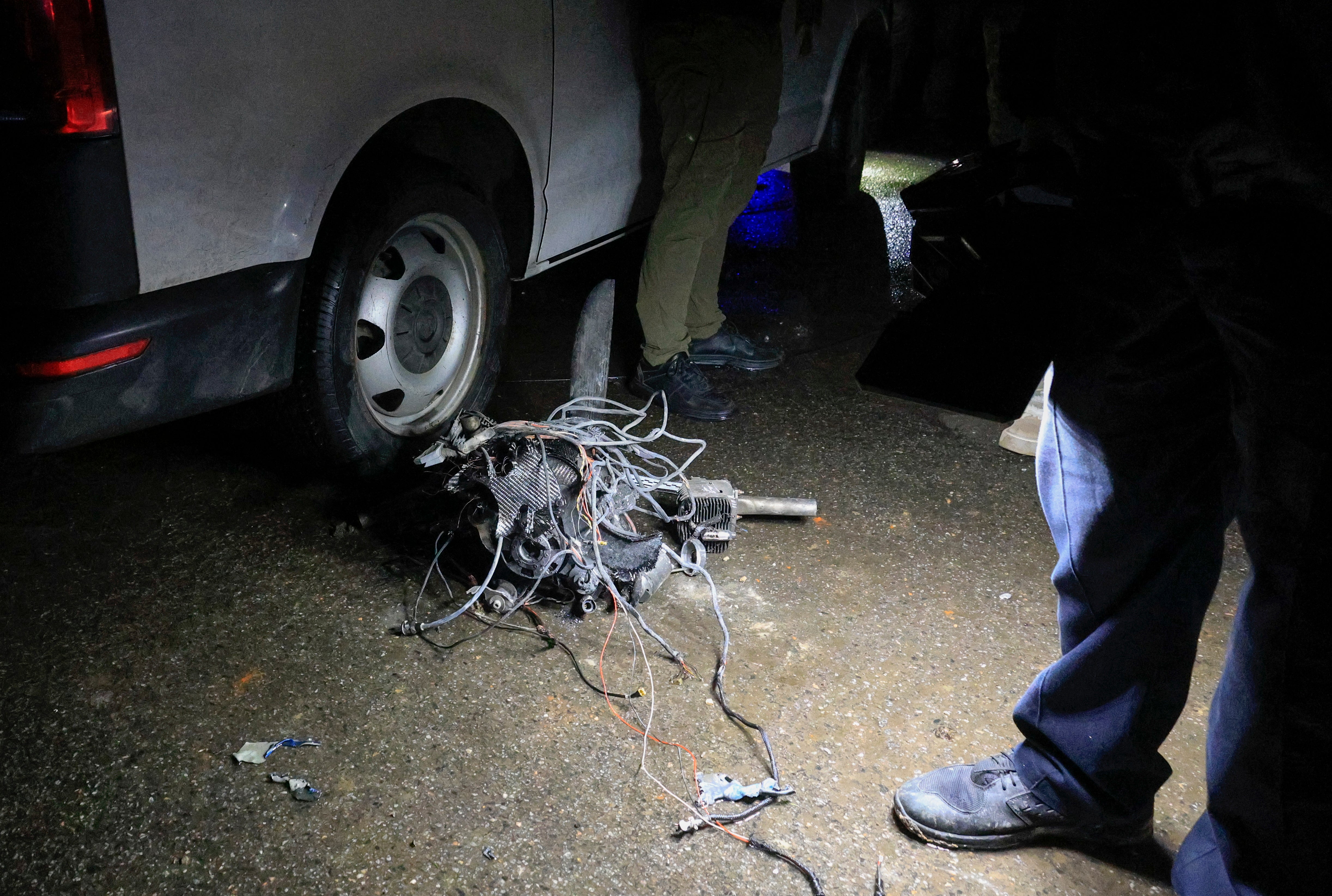 Ukrainian experts inspect a drone engine at the site of a shock drone strike in Kharkiv