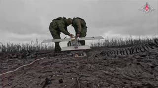 Russian soldiers prepare their drone to launch it towards Ukrainian positions on an undisclosed location in Ukraine
