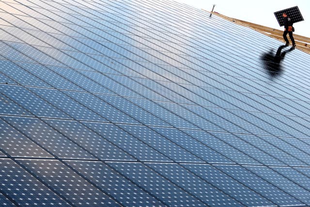 <p>Workers install solar panels on a 36,000 square meters solar panel installation in Weinbourg, Eastern France</p>