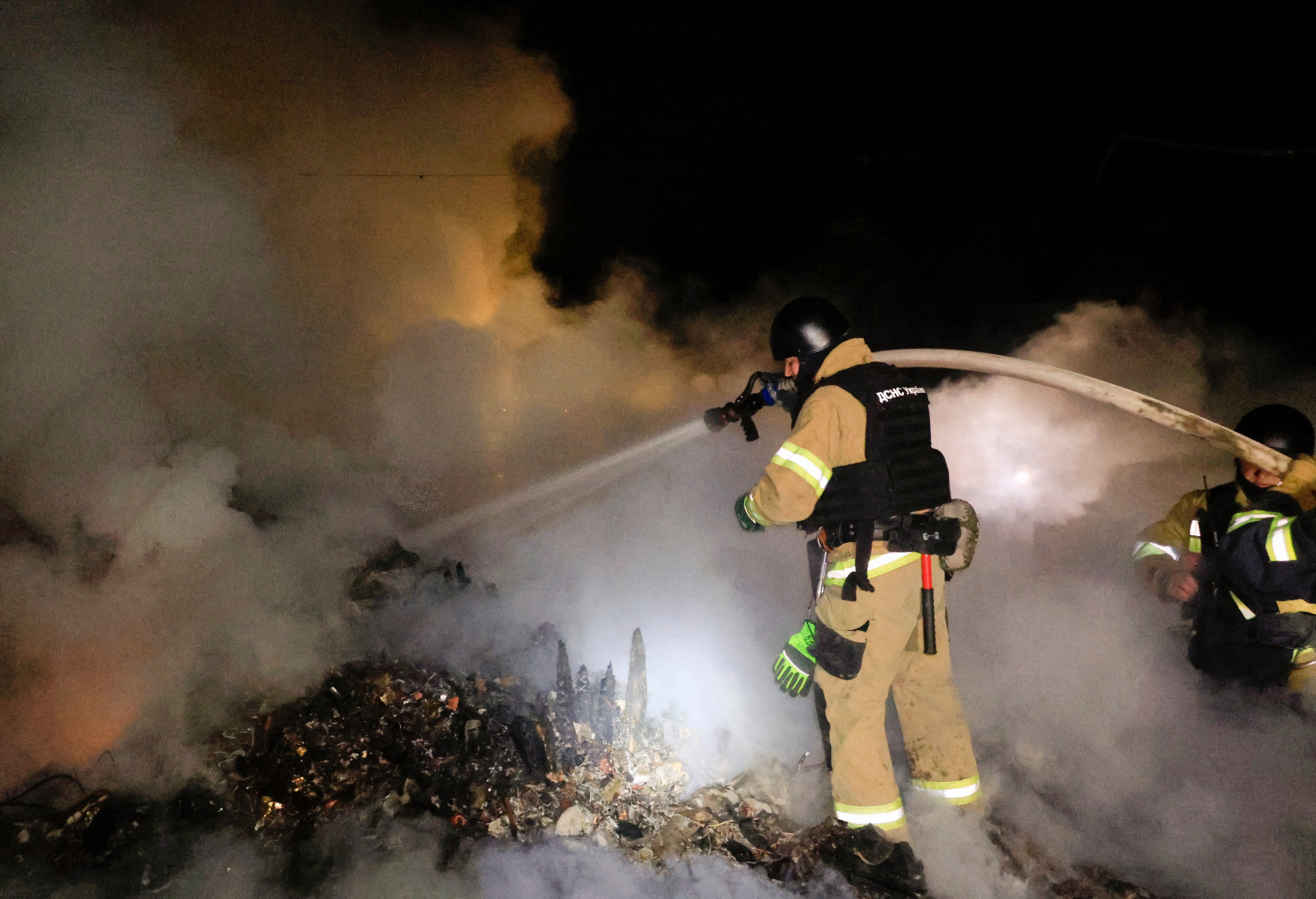 A firefighter battles a blaze in Kharkiv overnight