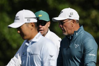Phil Mickelson of the US (R) and Michael Kim of the US (C) walk up the second fairway during a practice round