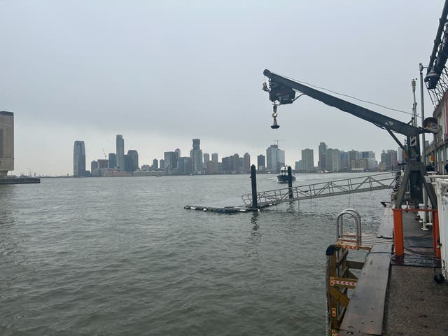 <p>A crane arm extends over the banks of the Hudson River in New York City where rescue workers raced to respond to a helicopter crash. The aircraft plummeted into the river on April 10, 2025</p>