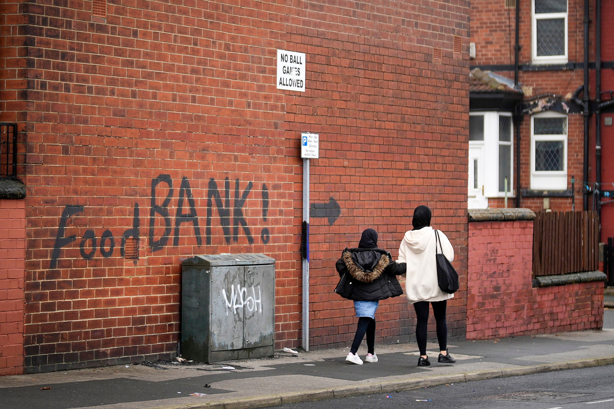 A sign painted on the side of a house directs people to a local food bank in Leeds, England