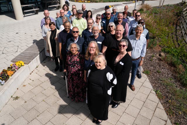 Twenty recipients of heart transplants and their families pose for a photograph at a celebration event at the Royal Papworth Hospital in Cambridge (Stefan Rousseau/PA)