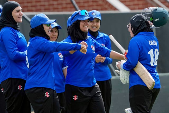<p>Afghan players congratulate top scoring batter Zazai as she walks off the field during their match against Cricket Without Borders XI at Junction Oval in Melbourne</p>