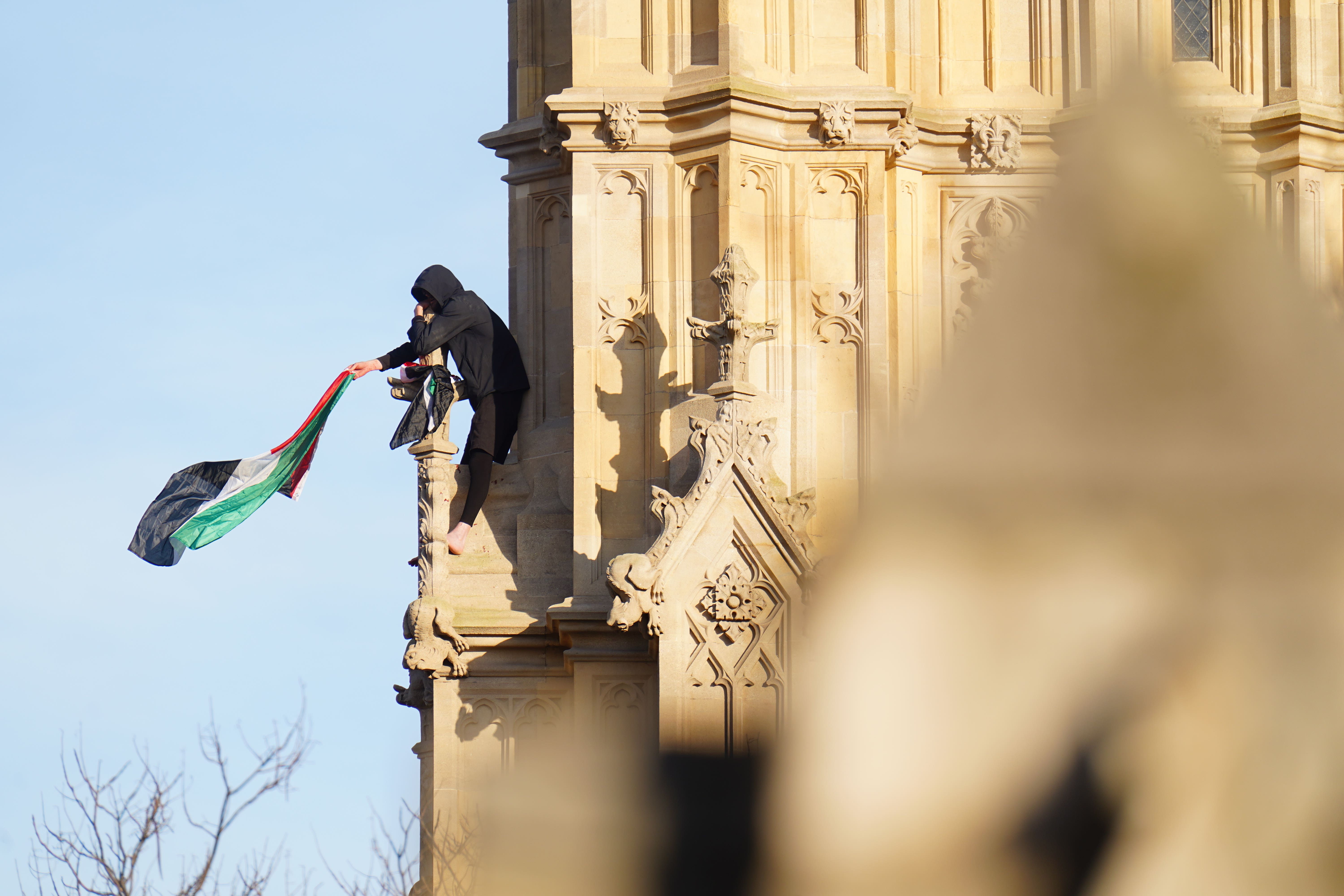 Daniel Day spent more than 16 hours barefoot and holding a Palestine flag on the Elizabeth Tower (James Manning/PA)