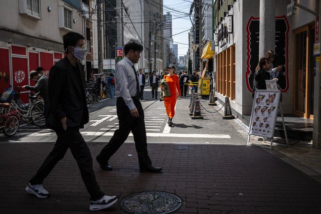 <p>Pedestrians walk along a street in Osaka, Japan</p>