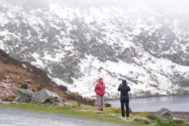 People looking at the snow at Lough Bray Upper on Powerscourt Mountain in co Wicklow (Niall Carson/PA)