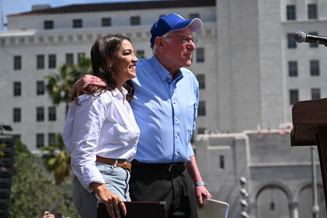 <p>US Senator Bernie Sanders, Independent from Vermont, and US Representative Alexandria Ocasio-Cortez, Democrat of New York, arrive during the "Fighting Oligarchy: Where We Go From Here" rally at Gloria Molina Grand Park in Los Angeles on April 12</p>
