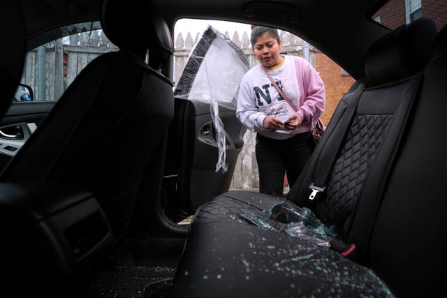 <p>Marilú Domingo Ortiz, cuyo marido fue detenido por agentes de ICE después de que rompieran una ventana de su coche familiar, mira los cristales rotos y los daños en su vehículo en su casa, el miércoles 16 de abril de 2025, en New Bedford, Massachusetts (AP Photo/Charles Krupa)</p>