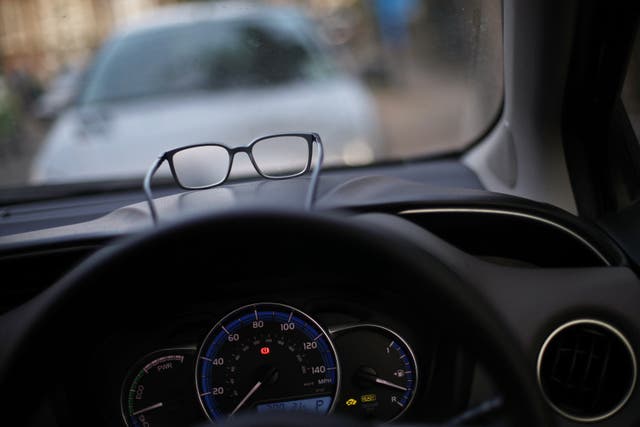 A pair of glasses resting on the dashboard of a car (Yui Mok/PA)