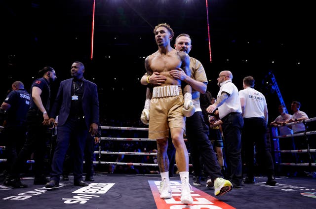<p>Ben Whittaker is restrained by his coach Andy Lee post-fight</p>