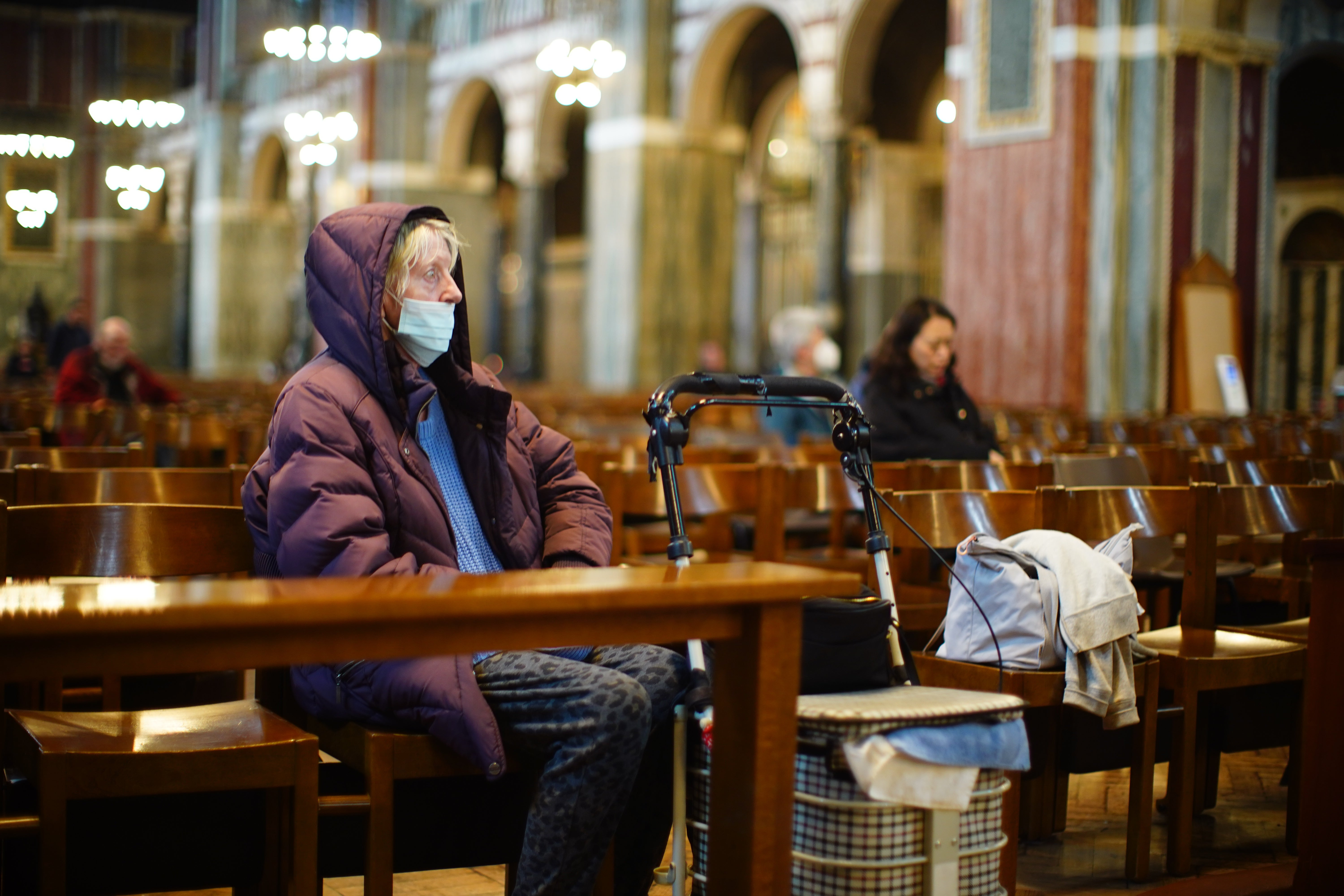As pessoas sentam -se na Catedral de Westminster, em Victoria, Londres, após o anúncio do Vaticano da morte do Papa Francisco.