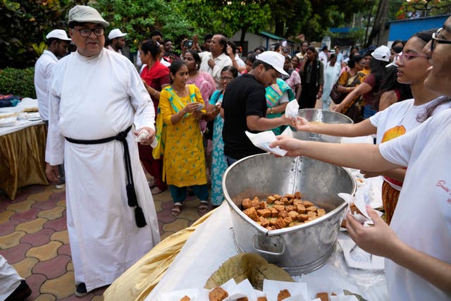 <p>Representative: Volunteers offer sweets to a Catholic priest and others at the end of a procession celebrating Easter Sunday commemorating the day in Kolkata, India</p>