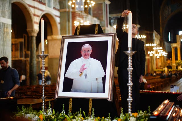 Mourners filed past a commemorative display lined with candles around a photo of the late pontiff (James Manning/PA)