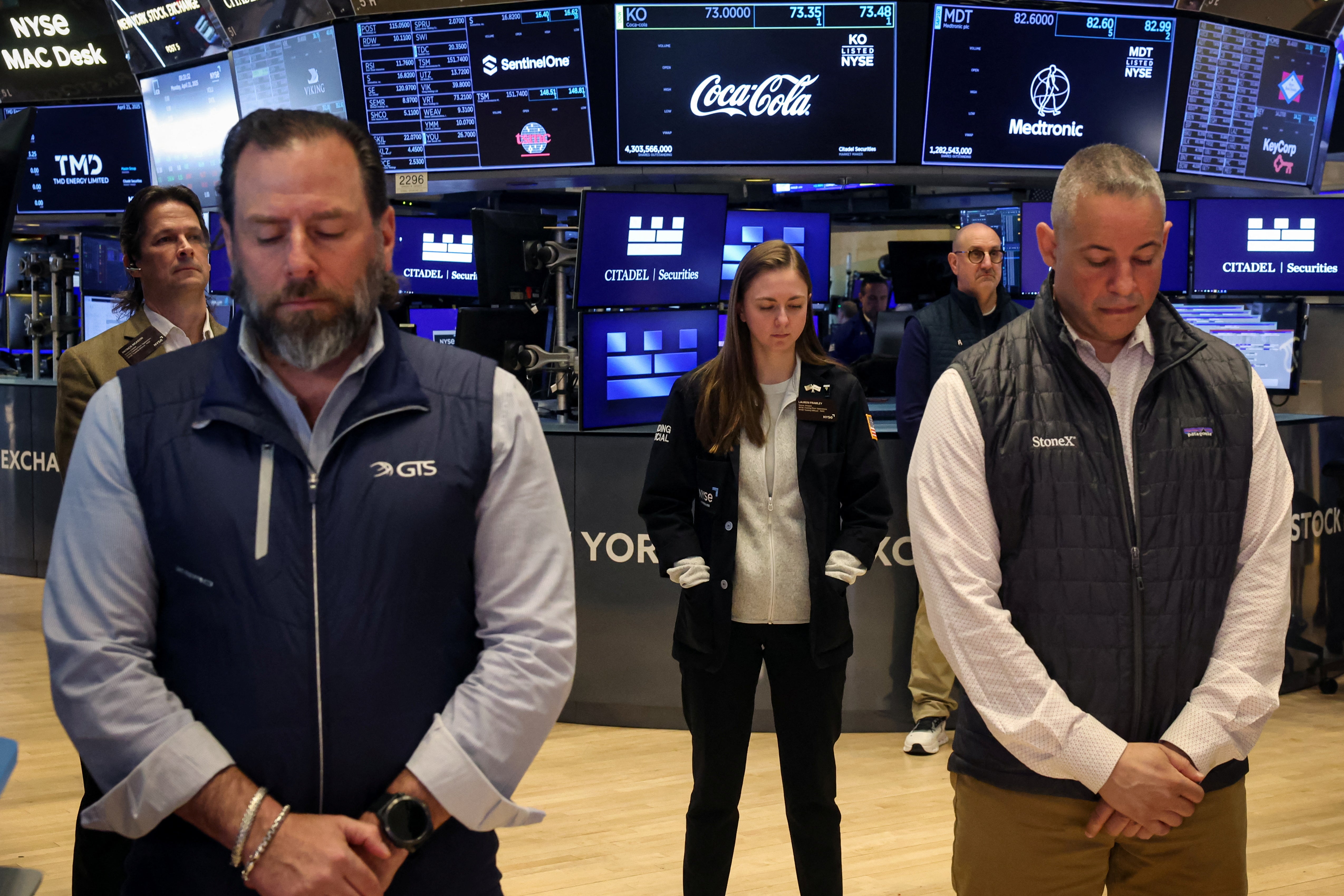 Traders hold a moment of silence on the floor at the New York Stock Exchange
