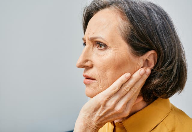 <p>Mature woman experiencing hearing problems touching ear with hand</p>