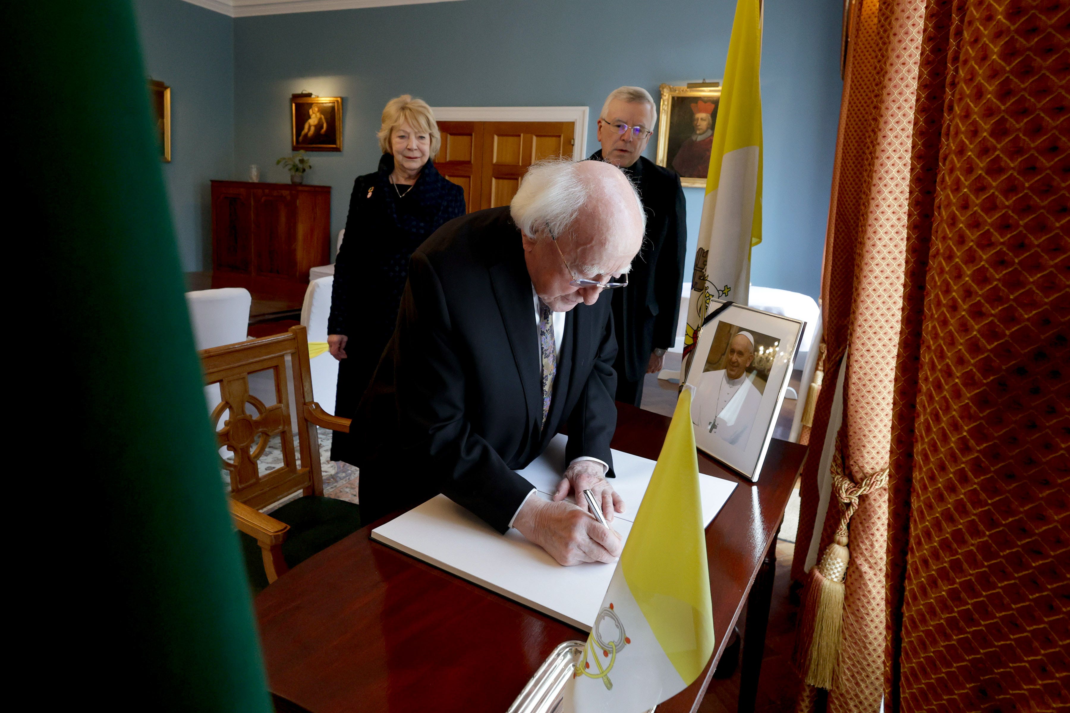President Michael D Higgins and his wife Sabina, with the Papal Nuncio Archbishop Luis Mariano Montemayor, signing a book of condolences for Pope Francis in Dublin (Maxwells/PA)