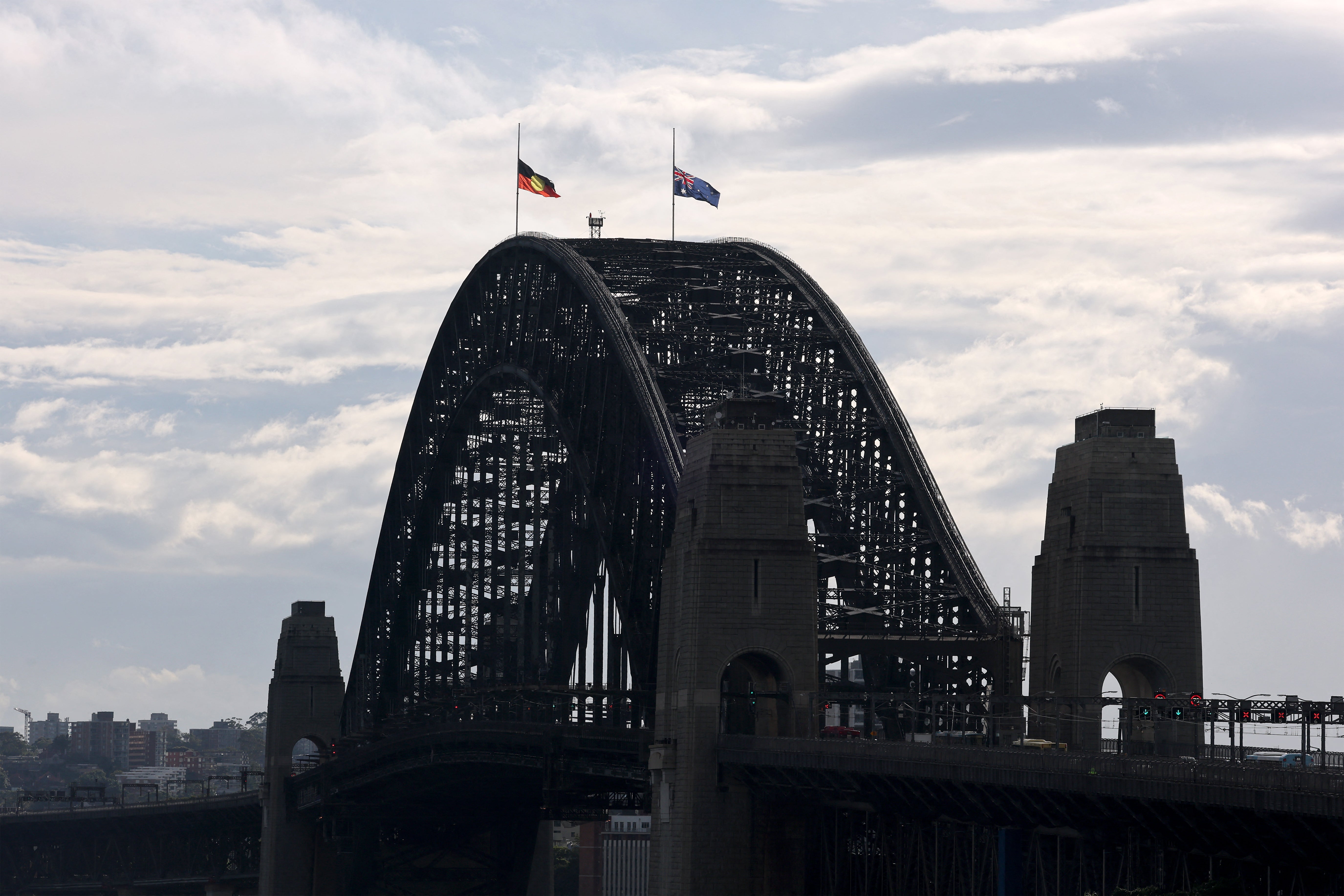 The Australian and Aboriginal flags fly at half-mast atop the Sydney Harbour Bridge in Sydney