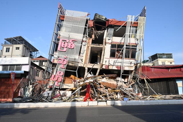 <p>Man walks past a building damaged by a powerful earthquake in Mandalay, Myanmar </p>