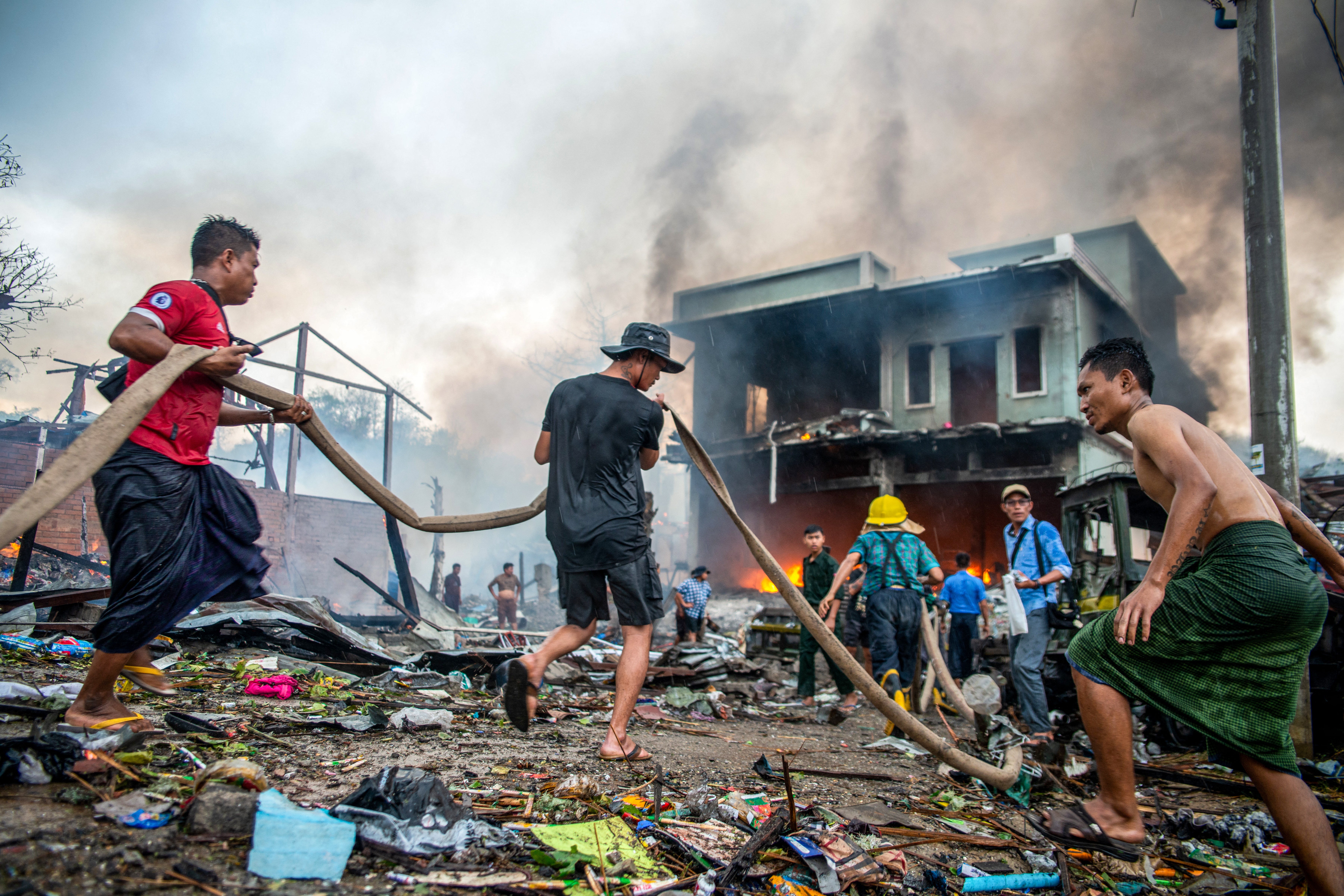 <p>People extinguish a fire in a building that was destroyed in a bombardment carried out by Myanmar's military in Thabeikkyin Township in Mandalay Region of Central Myanmar on 19 April</p>