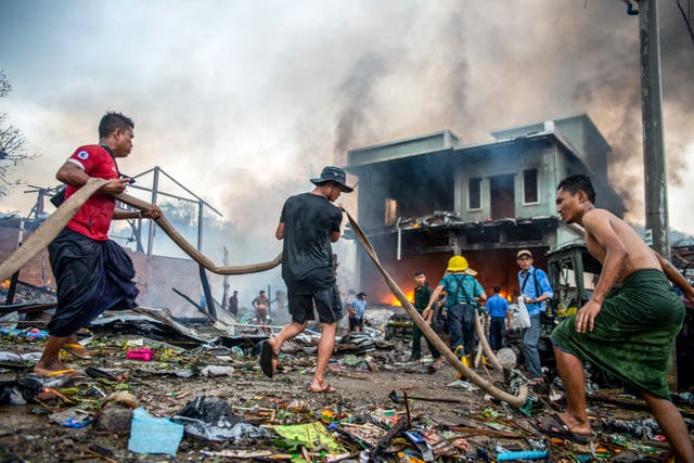 <p>People extinguish a fire in a building that was destroyed in a bombardment carried out by Myanmar's military in Thabeikkyin Township in Mandalay Region of Central Myanmar on 19 April</p>