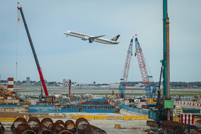 <p>Representative: A Singapore Airlines plane flies past a construction site at Terminal 2 of Changi Airport on 14 April 2025 in Singapore</p>