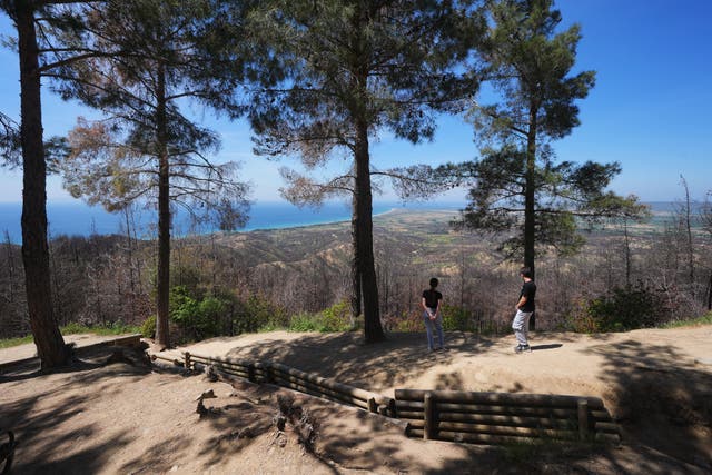 Visitors stand next to trenches at Chunuk Bair Cemetery – which commemorates New Zealand soldiers who died during the Gallipoli campaign (PA)