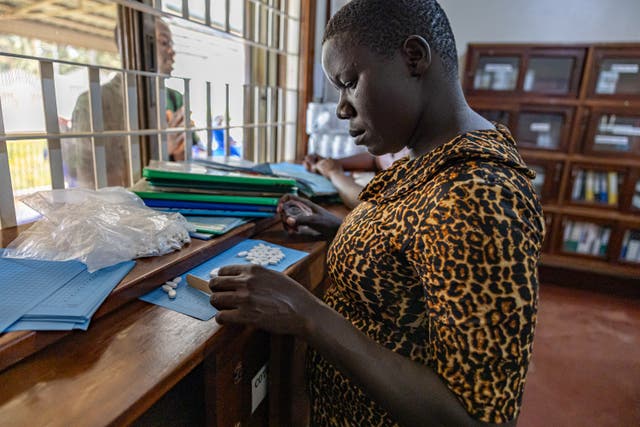 <p>A healthcare worker in the Family Hope Clinic in Uganda administers HIV medication </p>