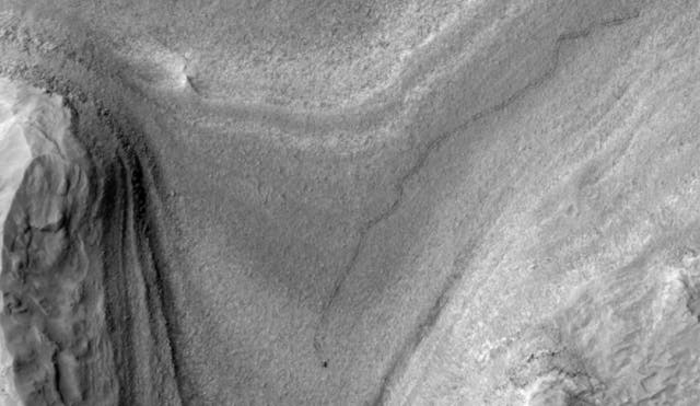 <p>NASA’s Curiosity rover appears as a dark speck in this contrast-enhanced view taken in February. The image marks the first time the rover was captured driving by the Mars Reconnaissance Orbiter</p>