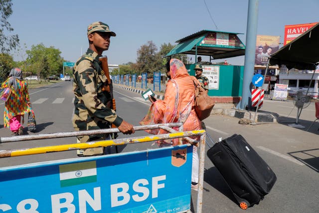 <p>People carry baggage as they cross a Border Security checkpoint at the Attari-Wagah border crossing on the India-Pakistan border, near Amritsar, India</p>