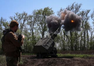 A serviceman of the 43rd Hetman Taras Triasylo Separate Artillery Brigade of the Ukrainian Armed Forces stands near an Archer self-propelled howitzer as it is fired towards Russian troops, amid Russia's attack on Ukraine, at a position in Zaporizhzhia region