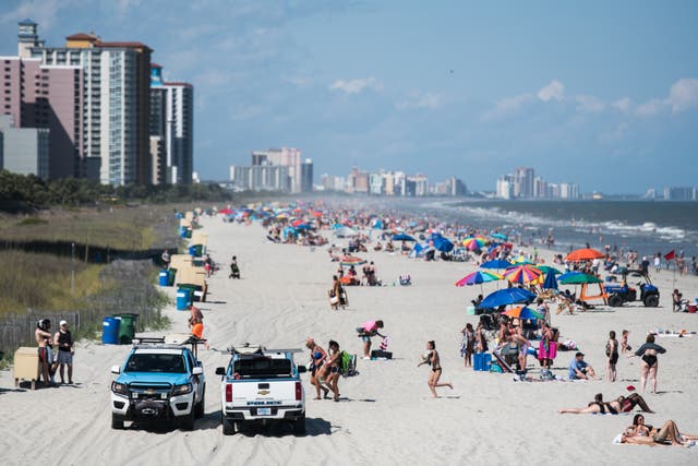<p>Beach Patrol police officers talk to beach goers from their vehicles on May 23, 2020, in Myrtle Beach, South Carolina</p>
