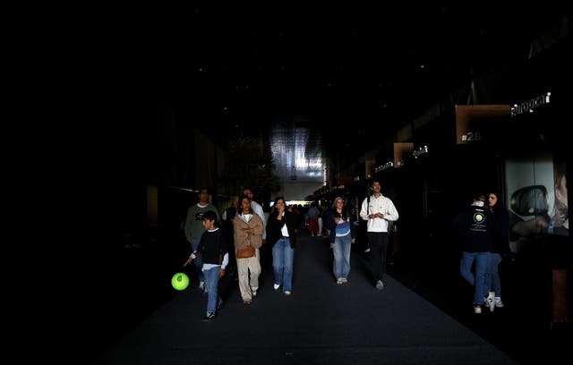 <p>Fans walk along dark gangways during a power outage at the Madrid Open</p>