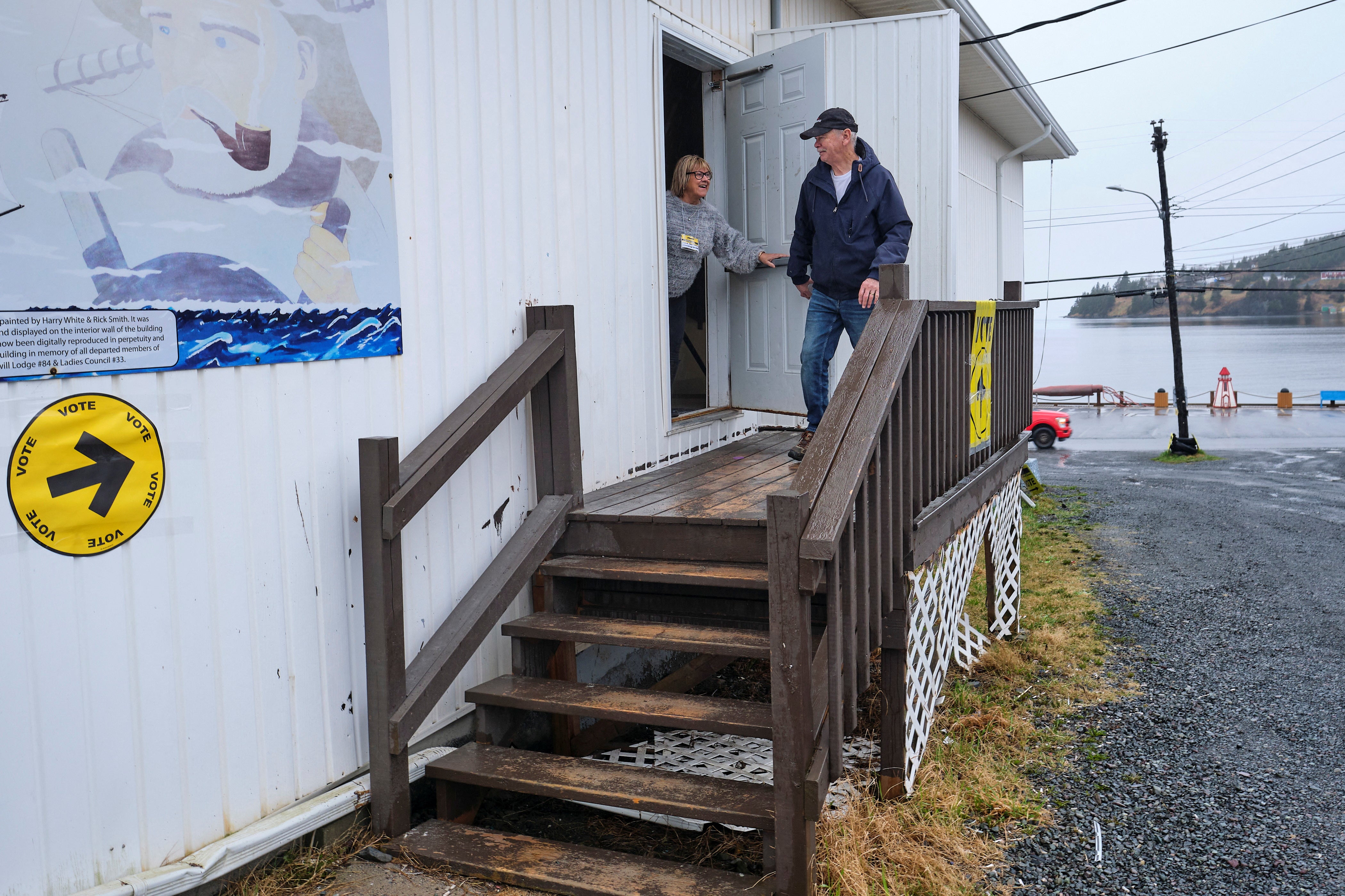 Earle Reid, the first voter at the polling station on the day of the election, reacts, in Dildo, Newfoundland