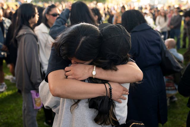 <p>Los asistentes se abrazan durante una reunión comunitaria en duelo por las víctimas del festival Lapu Lapu en Kensington Park</p>