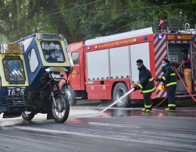<p>A handout photo made available by the Sorsogon Provincial Information Office (SPIO) shows firemen hosing a road covered with volcanic ash from the Bulusan volcano in the town of Juban, Sorsogon province, Philippines, 28 April 2025</p>