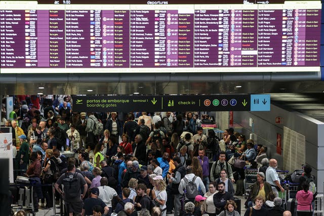 <p>Passengers wait at Humberto Delgado airport in Lisbon after most of the boarding controls resumed operations following a major blackout</p>
