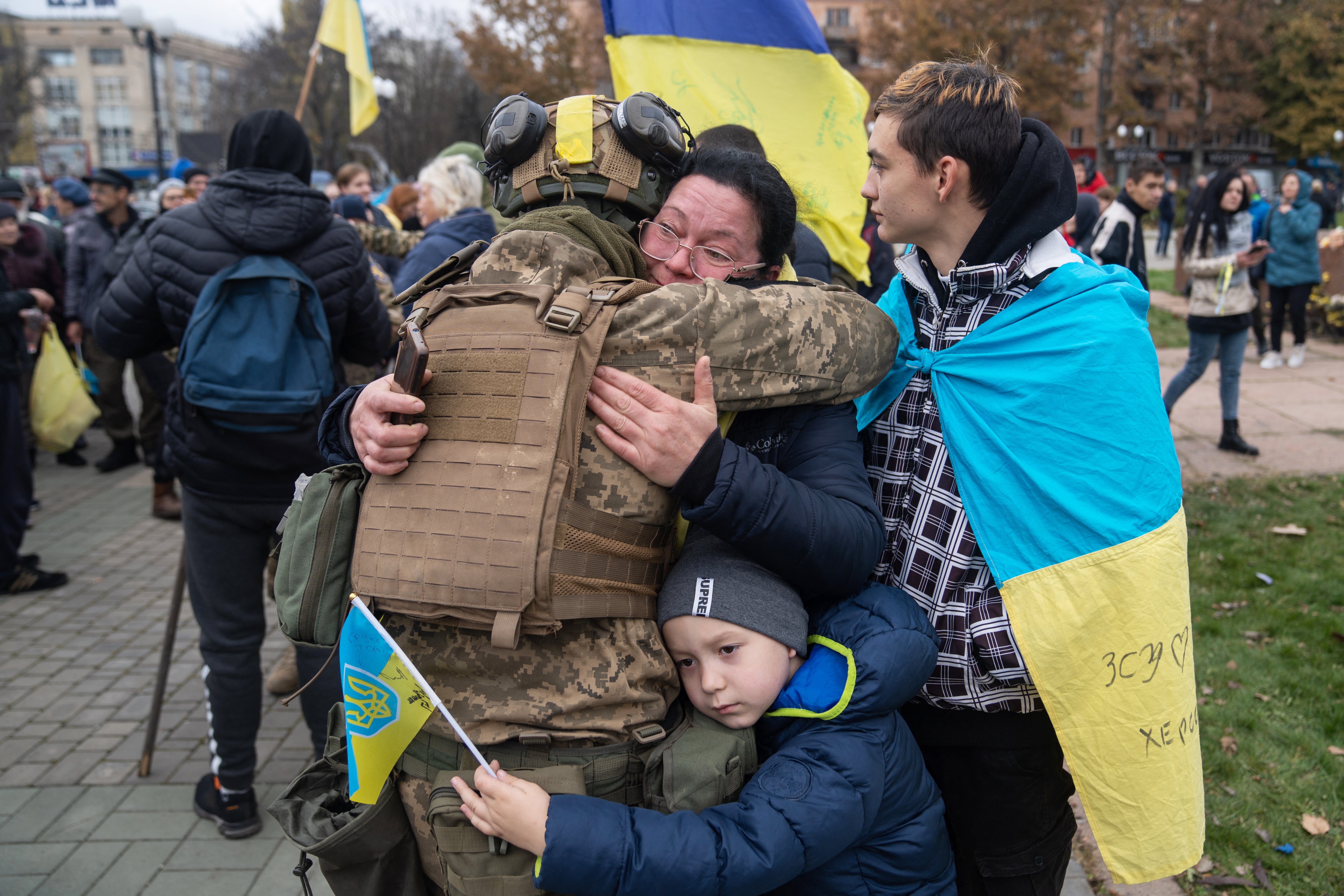 Local residents hug a Ukrainian soldier as they celebrate the liberation of Kherson, on November 13, 2022, amid Russia's invasion of Ukraine