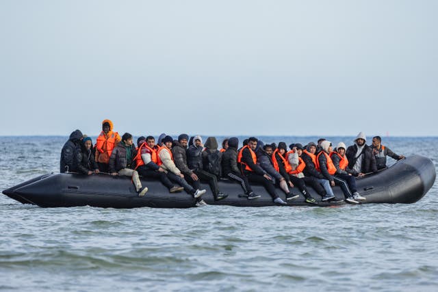 <p>Migrants board a smugglers’ boat in an attempt to cross the English Channel, off the beach of Gravelines, northern France, on 26 March</p>