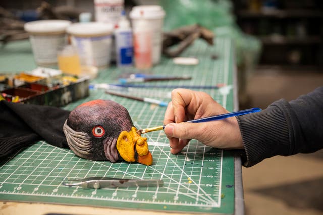 <p>EGAD Manager Carolyn Fuchs paints details on a king vulture hand puppet</p>
