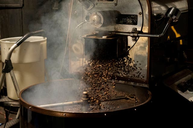 <p>Coffee beans fall into the cooling tray of a roasting machine at Fuego Coffee Roasters' roasting facility, Friday, March 21, 2025, in Rochester, N.Y</p>