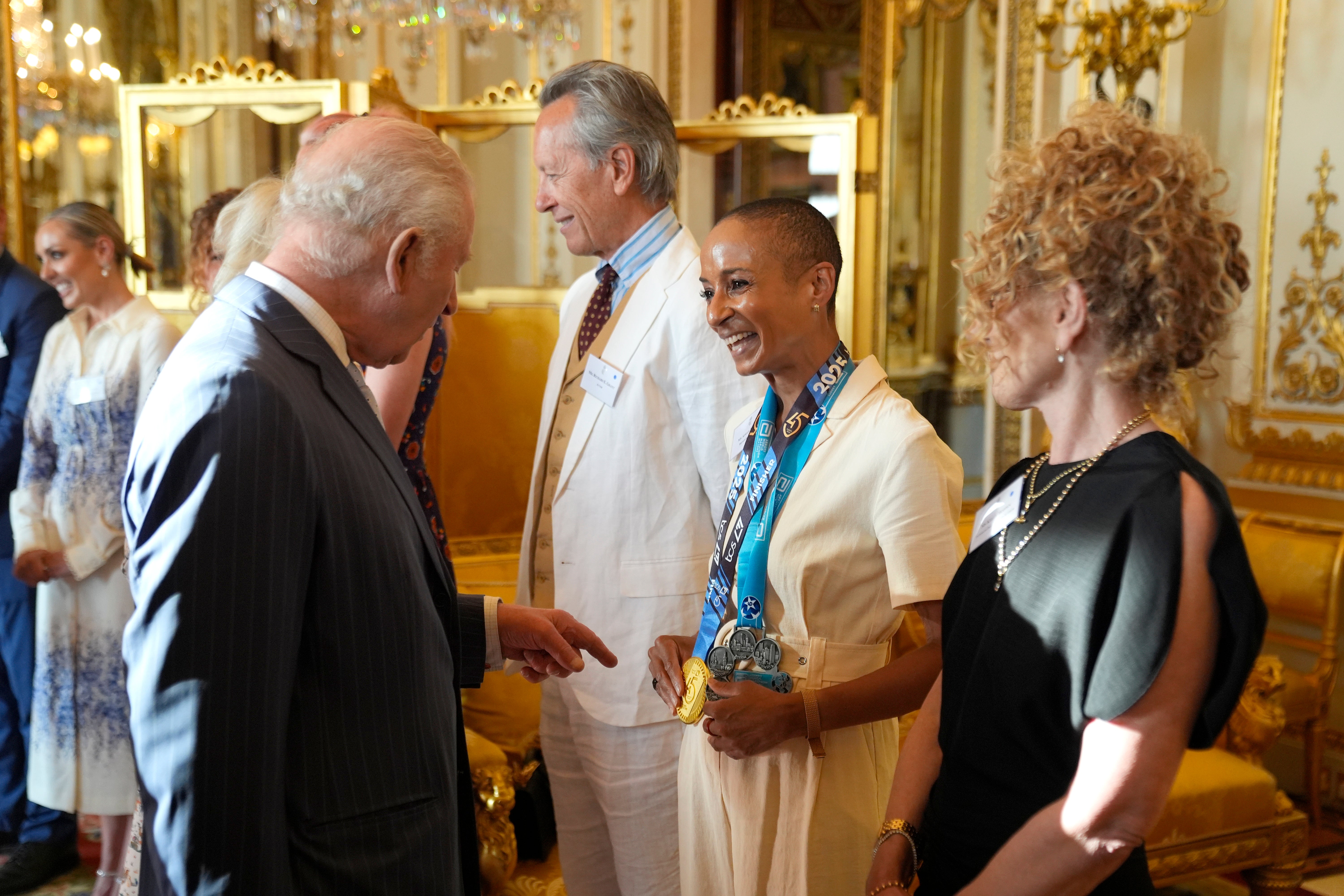 Charles speaks with broadcaster and presenter Adele Roberts during a reception in Buckingham Palace in celebration of organisations helping people with the disease