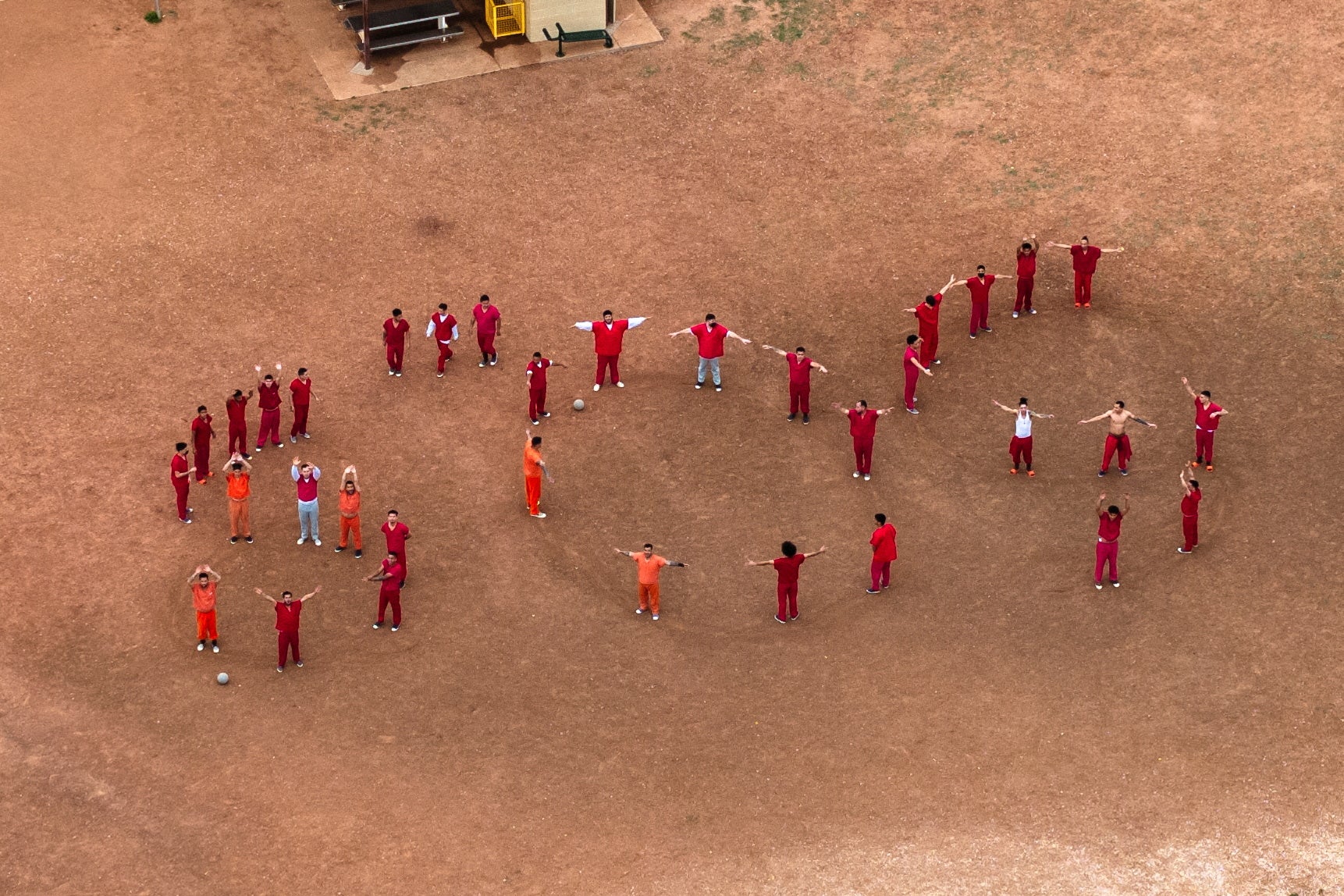 Venezuelan detainees forming the letters 'SOS' with their bodies in the courtyard at the Bluebonnet Detention Facility in Anson, Texas