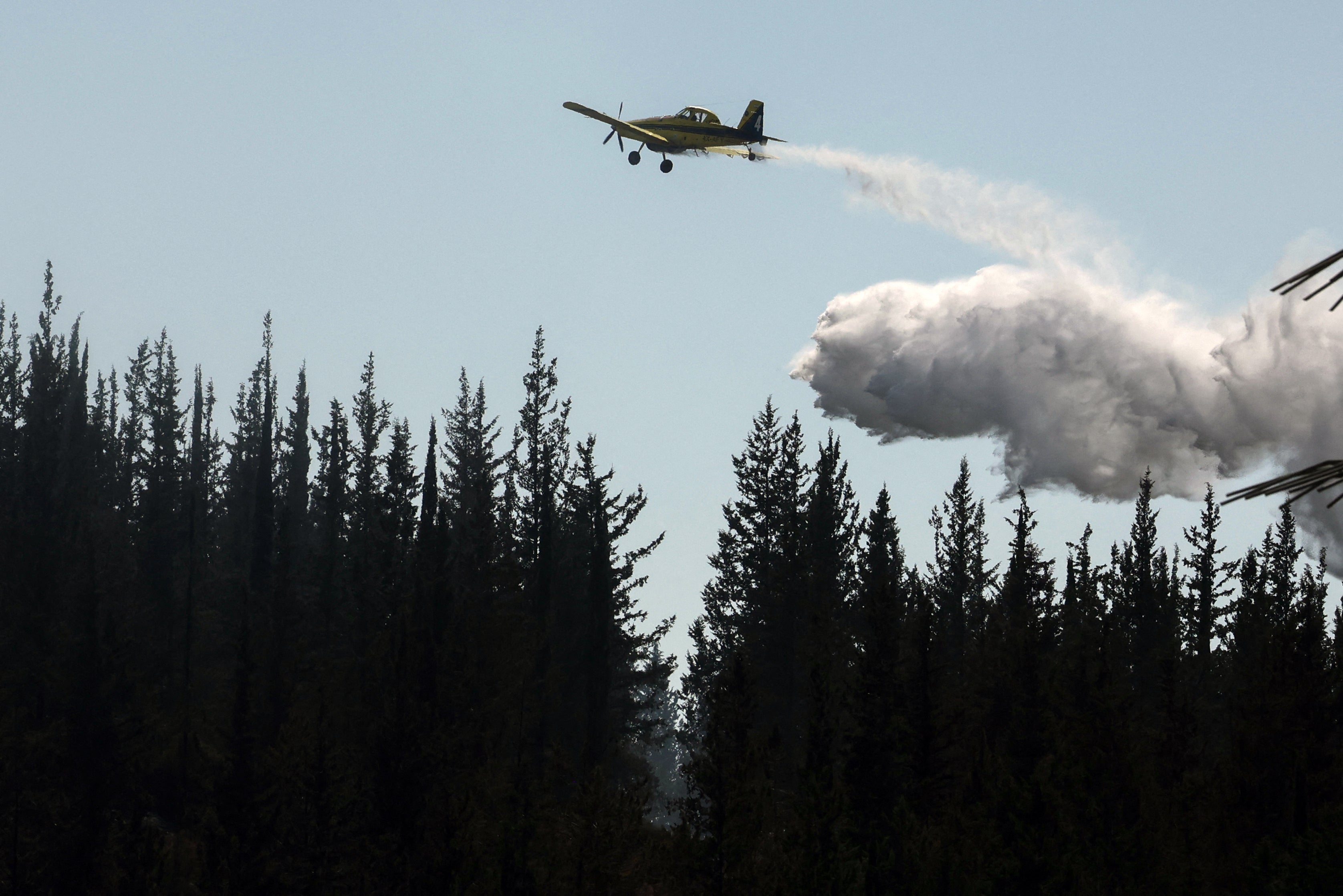 A firefighter airplane drops flame retardant while trying to extinguish a forest fire near the central Israeli town of Bet Shemesh, on May 2