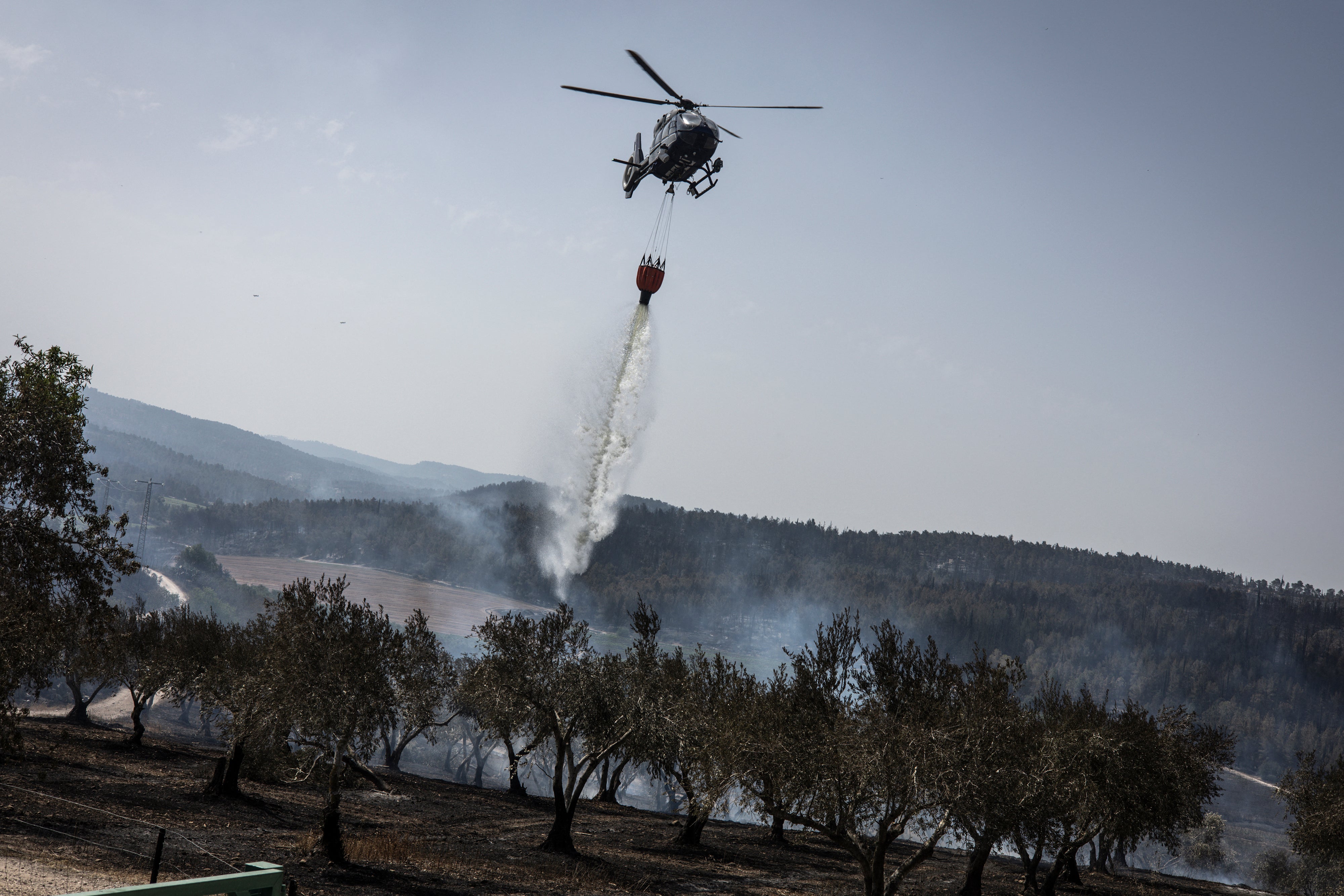 A firefighting aircraft dousing a fire with retardant in the Latrun area, in central Israel