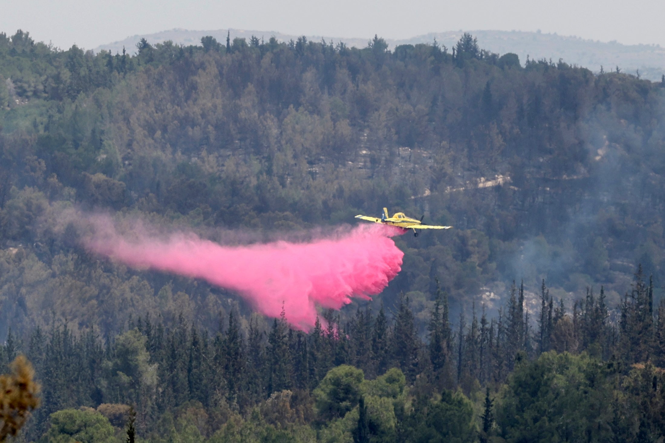 A firefighting aircraft dousing a fire with retardant in the Latrun area, in central Israel